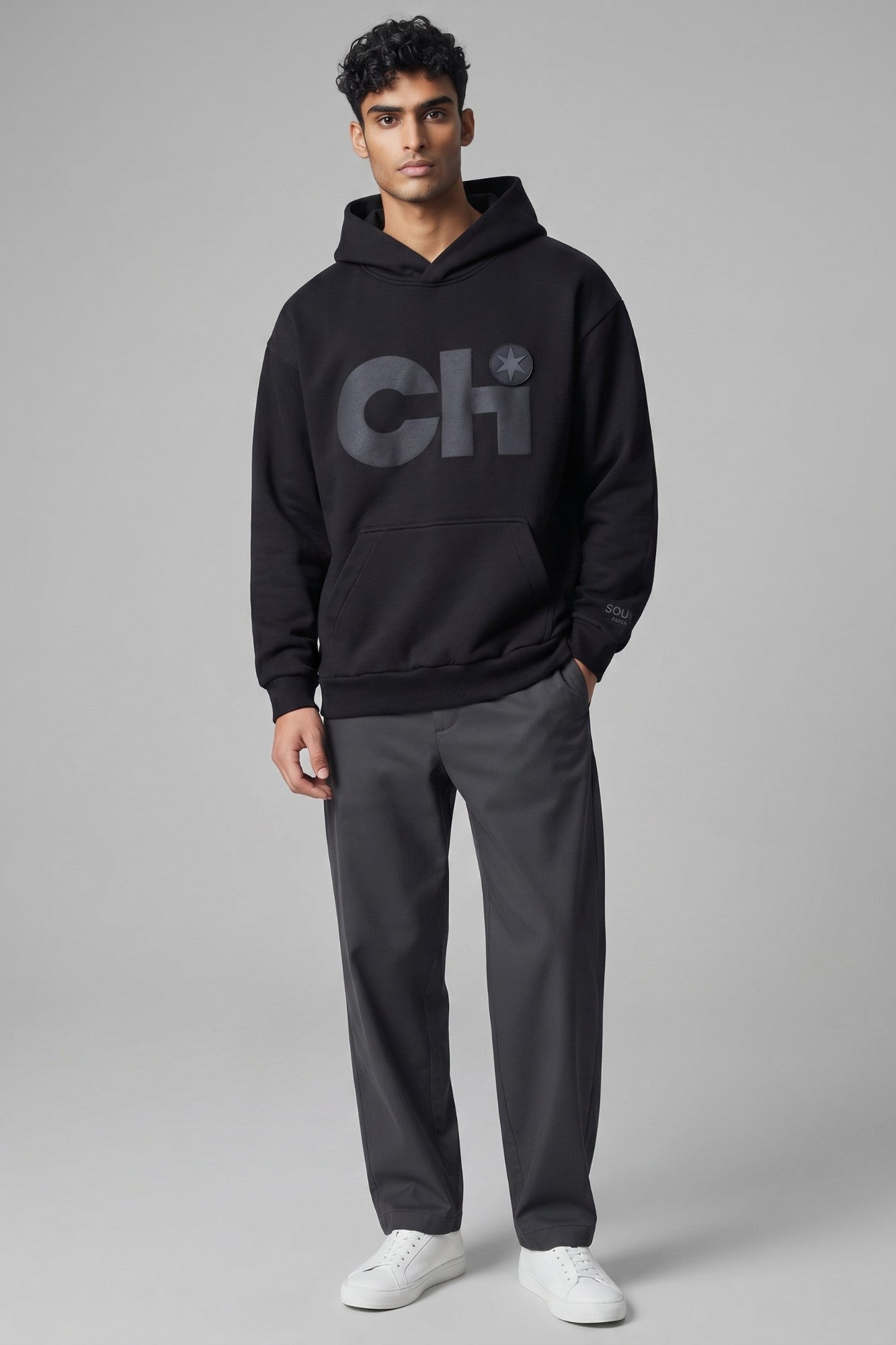 Male model wearing a Blackout Patch & Wear™ Chi hoodie with a removable six-point star PVC patch.