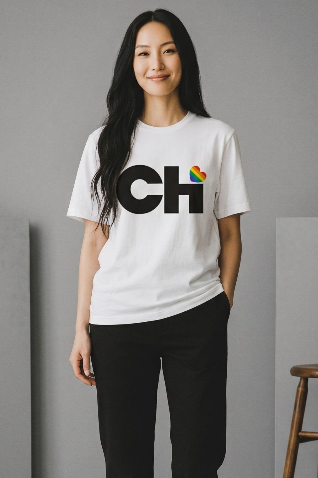 On-body view of the Love Chicago Pride t-shirt in white, featuring a bold black CHi graphic where a rainbow heart dots the I.
