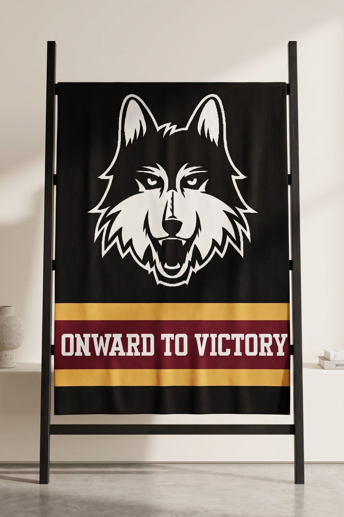 Loyola University Chicago varsity knit throw blanket in black, burgundy, and mustard gold with LUC Wolf head logo by SOUNDOFF - hanging