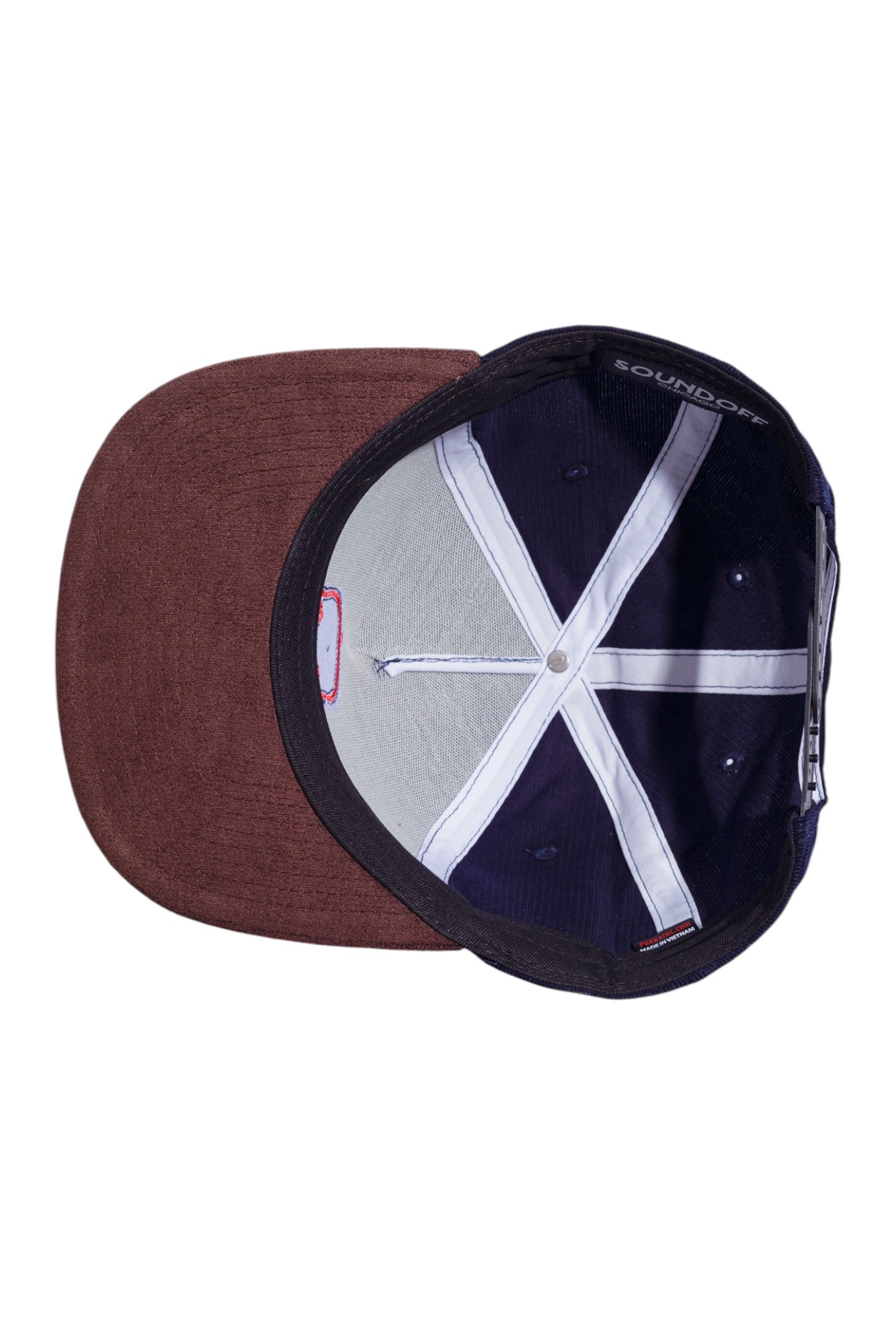 Underneath view of navy corduroy and brown suede snapback hat showing the undervisor and interior construction.