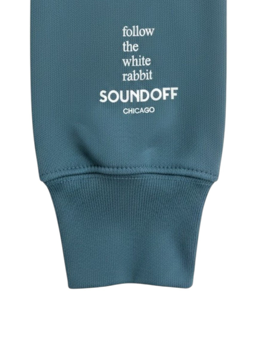 Close-up of the left sleeve on the Heather Teal Bad Bunny Headphones Raglan Sweatshirt, showing the stacked, left-justified "Follow the White Rabbit" text print above the cuff.