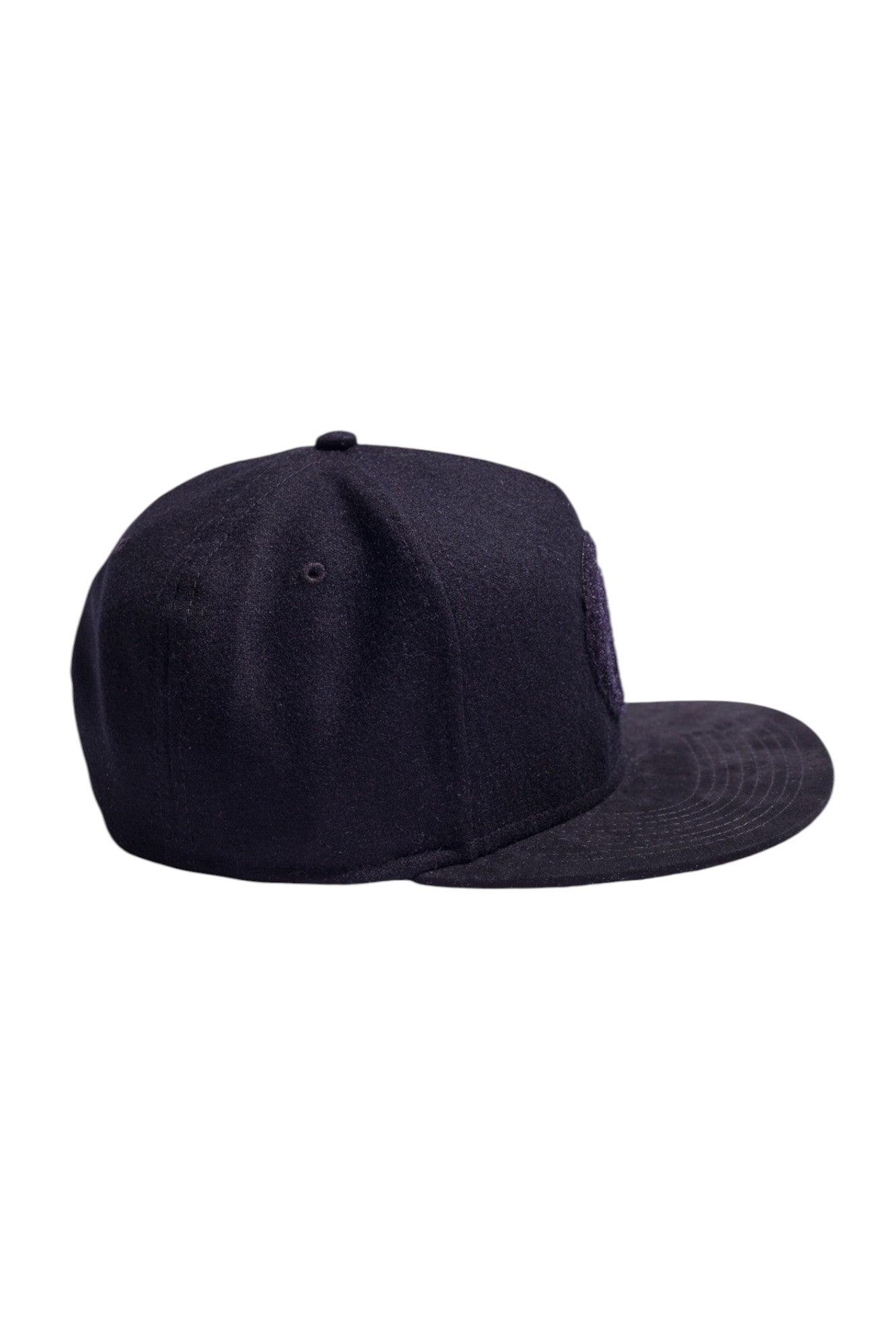 Side profile of black high-crown snapback highlighting suede and flannel texture.
