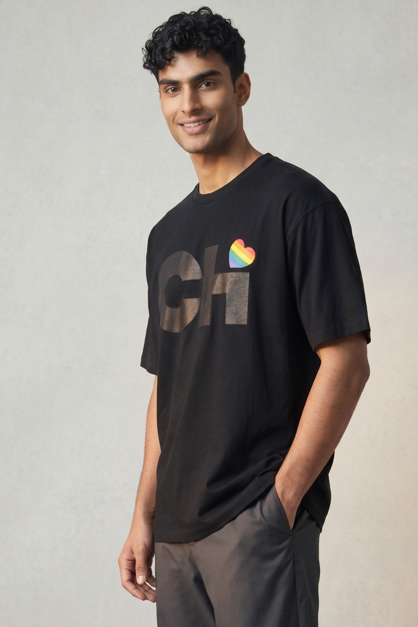 On-body view of the Love Chicago Pride t-shirt in black, featuring a bold black CHi graphic where a rainbow heart dots the I.
