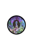 Circular sublimated Patch & Wear™ accessory featuring "All Love" artwork by Martha Wade; vibrant illustration of a woman in a meditative pose with a Chicago skyline backdrop.