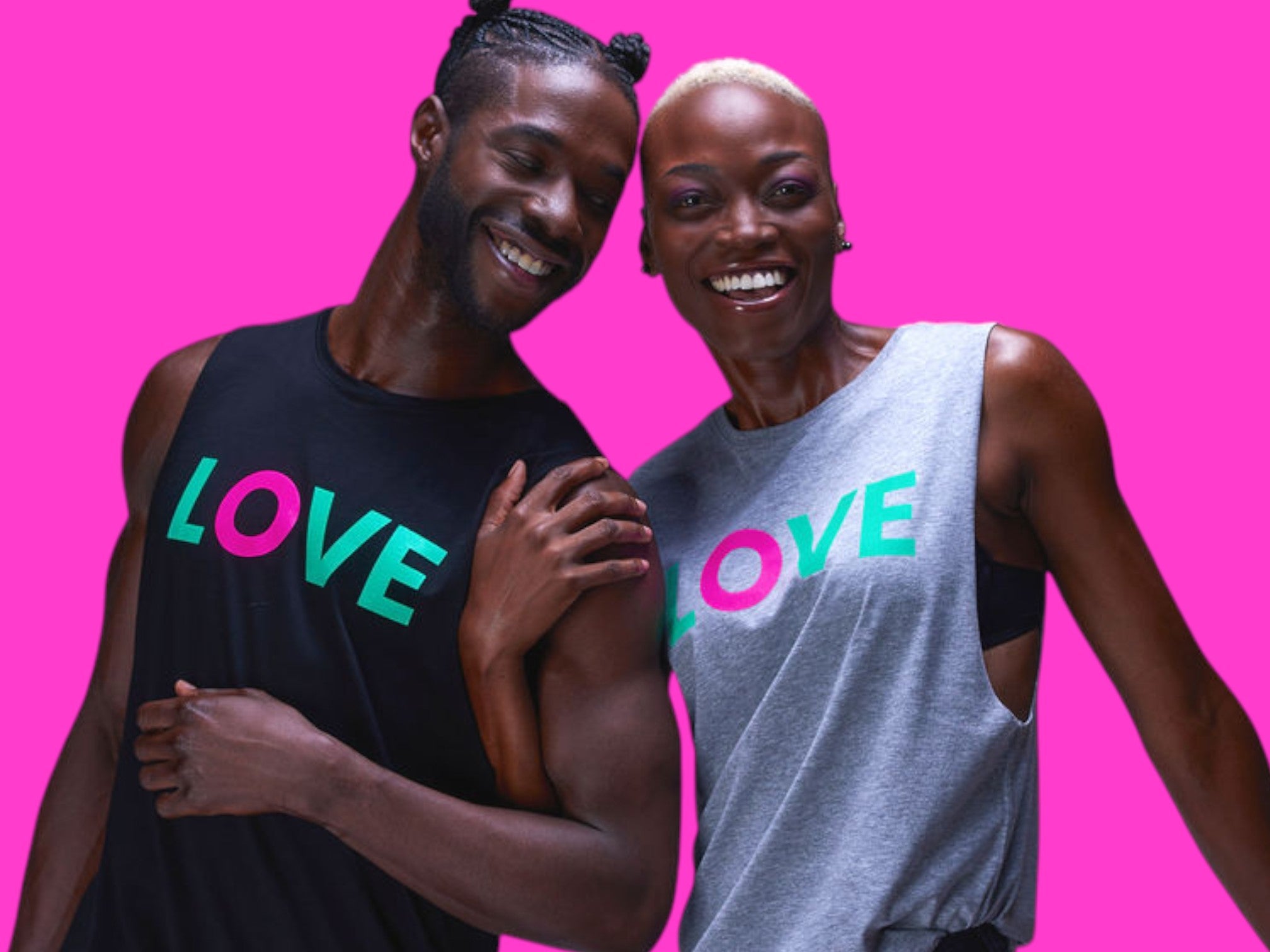 Two people wearing sleeveless tops with 'LOVE' printed on them against a pink background