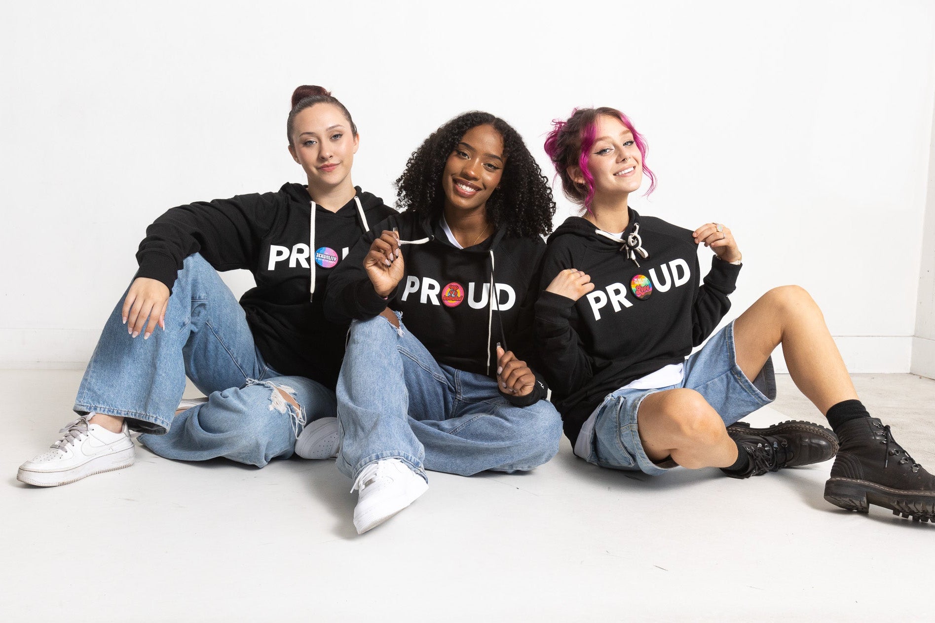 Three People wearing Patch and Wear Hooded Pullovers in Black with Patches